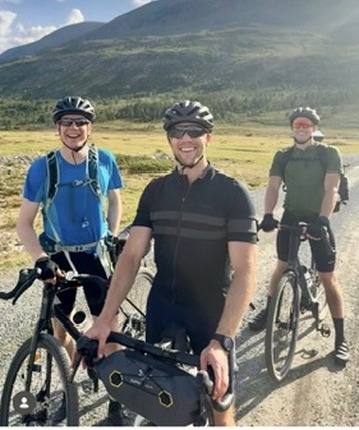 Three cyclists on a gravel road in the Norwegian mountains